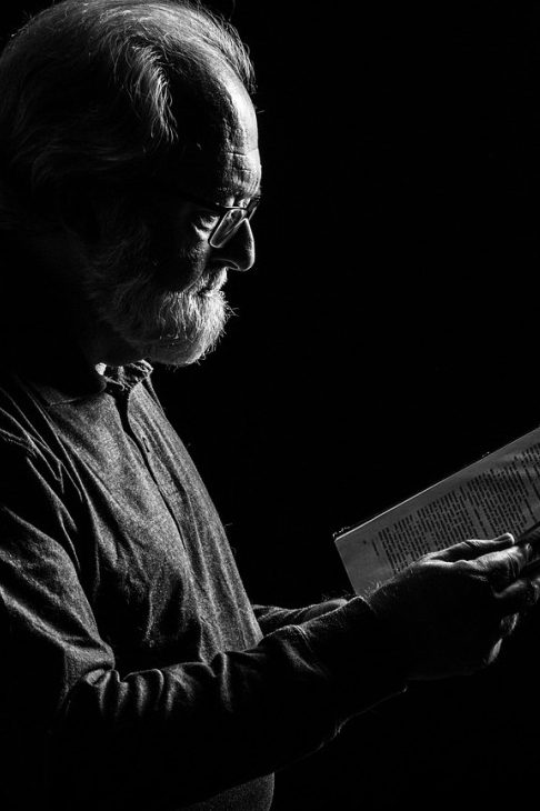 Ηλικιωμένος μοναχός διαβάζει σε σκοτεινό περιβάλλον